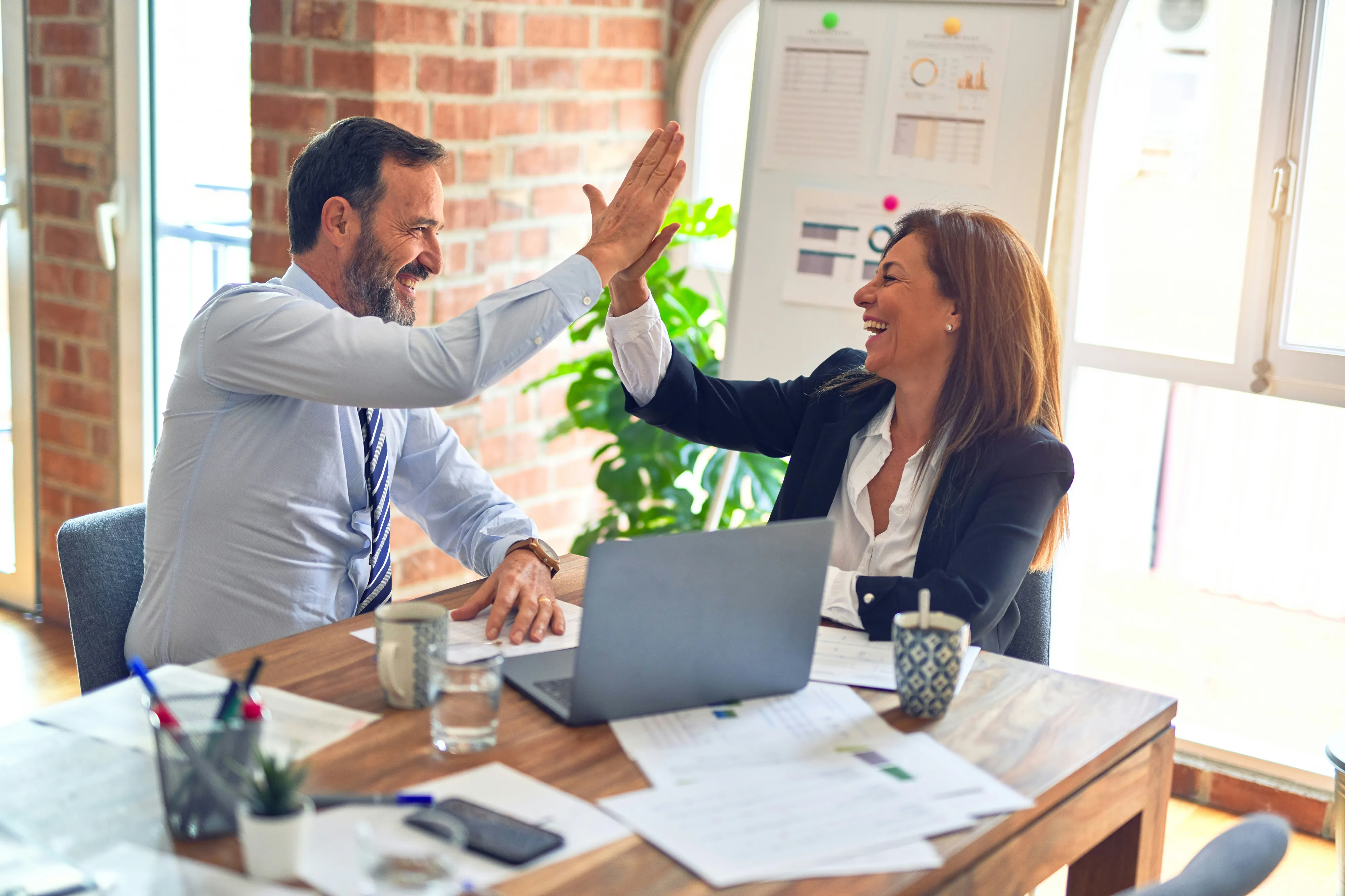 Trusted adviser and business leader walking through a modern office in conversation.