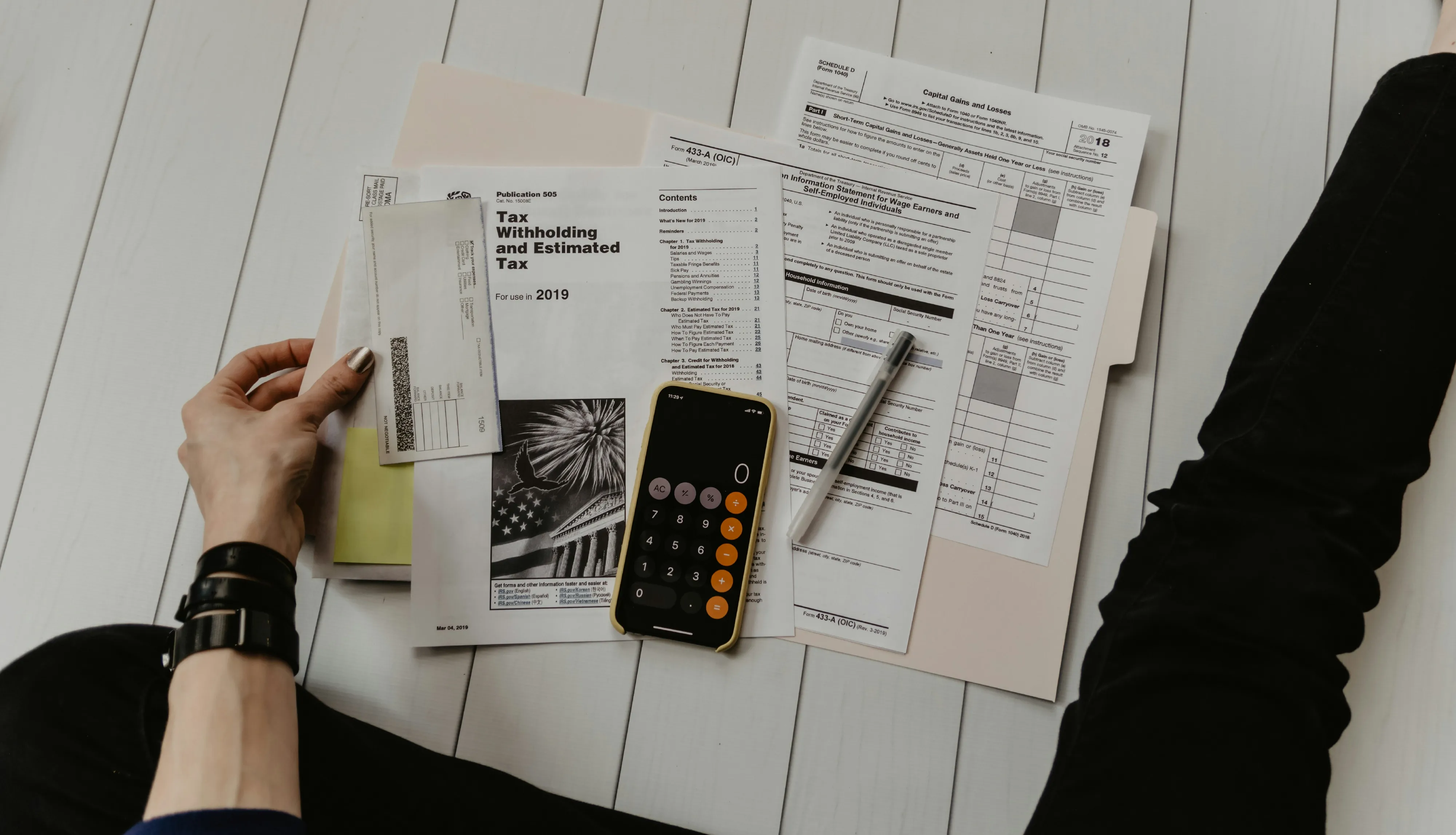 Professional writing a considered note during a financial consultation.